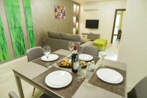 a living room with a table with plates and wine glasses at Noris Apart with Garage in Plovdiv