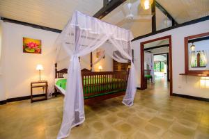 a bedroom with a canopy bed in a room at The Berrycove Bungalow in Kurunegala