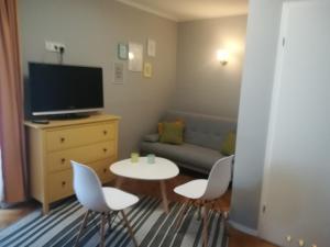 a living room with a tv and a table and chairs at Homestay Willa Anna in Karpacz