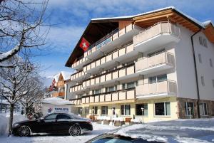 a black car parked in front of a hotel at Hotel Crystal in Engelberg