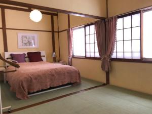 a bedroom with a bed and two windows at Naeba Ski Resort - Cottage away from usual life in Yuzawa