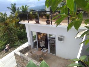un balcone di una casa con sedie e tavoli di Seaview Mansion Dalaguete Apartment 4 -Family a Dalaguete