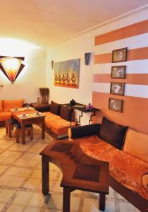 uma sala de estar com sofás e uma mesa em Riad Chalymar em Marrakech