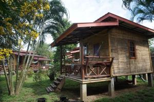 a small wooden house with a porch at Family Hut Pai in Pai
