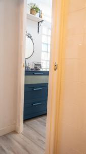 La salle de bains est pourvue d'un lavabo et d'une commode bleue. dans l'établissement El parador de la artesana, à Cadix