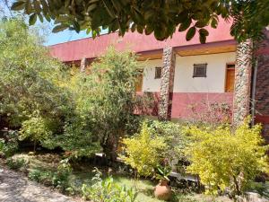 a building with trees and bushes in front of it at Top Twelve Hotel - Lalibela in Lalibela