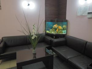 een woonkamer met een bank en een aquarium bij Parus Park-hotel in Moskou