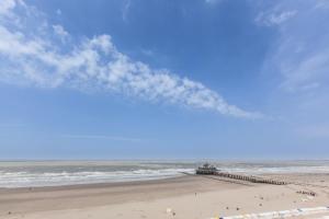a view of a beach with a pier and the ocean at Hotel Riant-Séjour by WP Hotels in Blankenberge