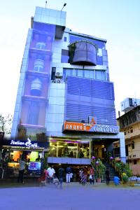um edifício azul alto com pessoas à frente dele em Ananya Comfortss em Hospet