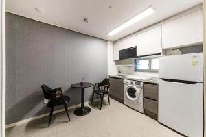 uma cozinha com uma mesa e cadeiras e um frigorífico em It's W em Suwon