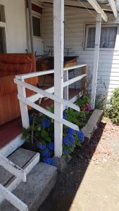 a white fence on the side of a house with flowers at Cabañas Patricia Licanray in Licán Ray