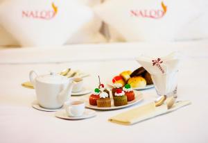 a table topped with cupcakes and cups of tea at The Nalod Da Nang in Danang