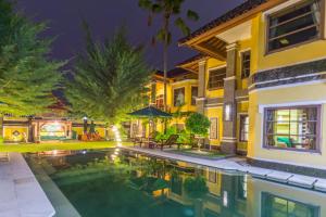 a house with a swimming pool at night at Apel Villa Sanur in Sanur
