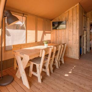 una mesa de madera y sillas en una habitación en HolaCamp Sitges Garrofer, en Sitges