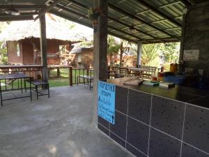 a patio with tables and a sign on a counter at Family Hut Pai in Pai