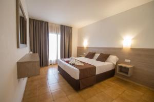 a hotel room with a bed and a window at Hotel Hipica Park in Platja  d'Aro