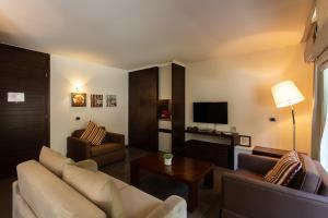 a living room with a couch and a tv at Eleven Hotel in Kfardebian