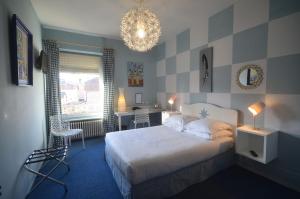 una camera da letto con un letto e un lampadario di Hôtel Vauban a Belfort