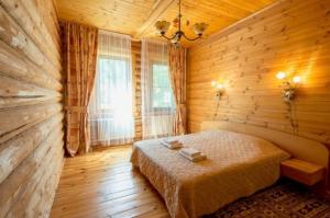 1 dormitorio con 1 cama en una habitación de madera en BKC Country, en Sosnoviy Bor