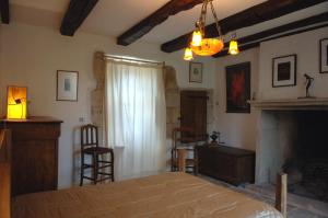 1 dormitorio con 1 cama y chimenea en LES HAUTS DU CAUSSE, en Grand-Mas