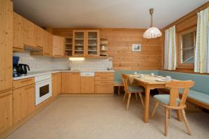 eine Küche mit Holzschränken sowie einem Tisch und Stühlen in der Unterkunft Abelhof in Schladming