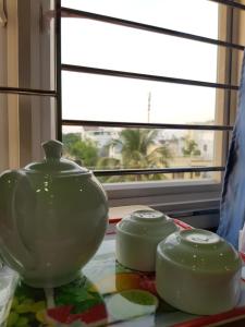 two green vases sitting on a table next to a window at Minh Kim Guesthouse in Ấp Phó +50 photos