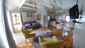 een woonkamer met een bank, stoelen en een tafel bij Aan De Vliet Guest House in Stellenbosch