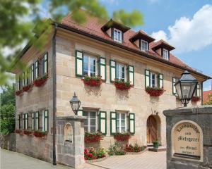 Kalchreuth的住宿－Landgasthof Meisel，一座大型砖砌建筑,窗户上布满了鲜花