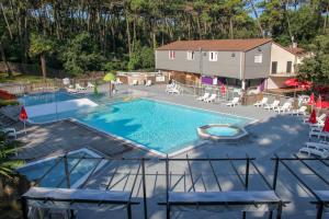a swimming pool with a pool table and chairs at Océan Vacances - Camping Paradis in Saint-Georges-de-Didonne