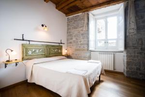 um quarto com uma cama e uma grande janela em Borgo San Pietro em Agnone