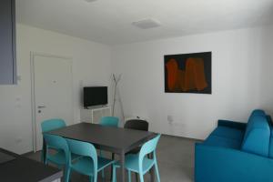 Un comedor con una mesa y sillas azules. en Residenza Cinisca, en Arco