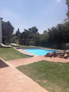 a swimming pool in the middle of a yard at Ecotel Southgate in Southgate