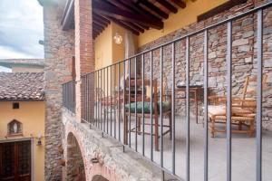 un balcón de una casa con mesa y sillas en Una Terrazza nel Centro Storico en Barga