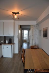 a kitchen and dining room with a table and chairs at Residentie Les Algues 8ste verdieping in Blankenberge