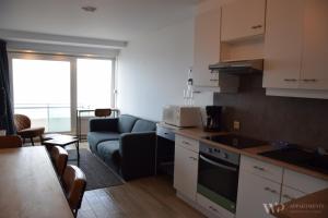 a kitchen with a couch and a living room at Residentie Les Algues 8ste verdieping in Blankenberge +10 photos