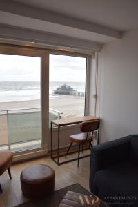 a living room with a table and a view of the beach at Residentie Les Algues 8ste verdieping in Blankenberge