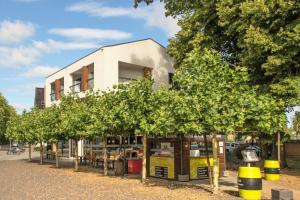 a row of trees in front of a building at Radlon Fahrrad-Komfort-Hotel in Waren