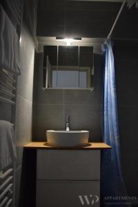 La salle de bains est pourvue d'un lavabo et d'un miroir. dans l'établissement Residentie Caraibes, 9de verdieping, à Blankenberge
