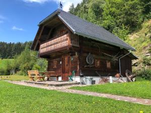 a large wooden cabin with a picnic table in front of it at Waldheimathütte in Sankt Kathrein am Hauenstein