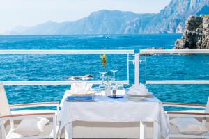 a table and chairs on a boat in the ocean at Grand Hotel Tritone in Praiano