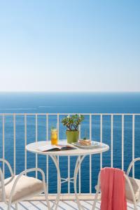 a table and chairs on a balcony with the ocean at Grand Hotel Tritone in Praiano
