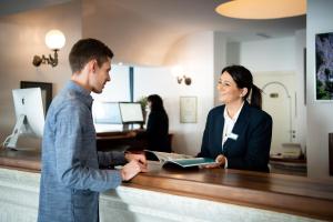 a man and a woman standing at a cash register at Grand Hotel Tritone in Praiano