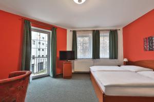a hotel room with two beds and a television at Attic Hotel in Prague