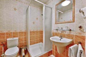 a bathroom with a toilet and a sink and a shower at Attic Hotel in Prague