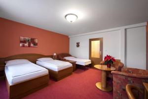a hotel room with two beds and a table at Attic Hotel in Prague