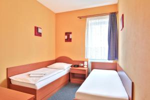 a room with two beds and a window at Attic Hotel in Prague