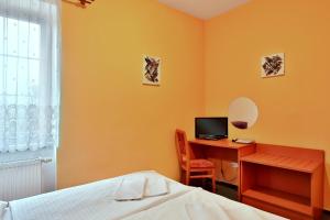 a bedroom with a bed and a desk with a computer at Attic Hotel in Prague