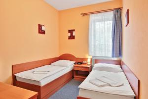 a room with two beds and a window at Attic Hotel in Prague