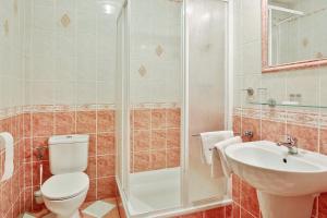 a bathroom with a shower and a toilet and a sink at Attic Hotel in Prague