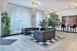 a living room with a couch and some plants at Attic Hotel in Prague